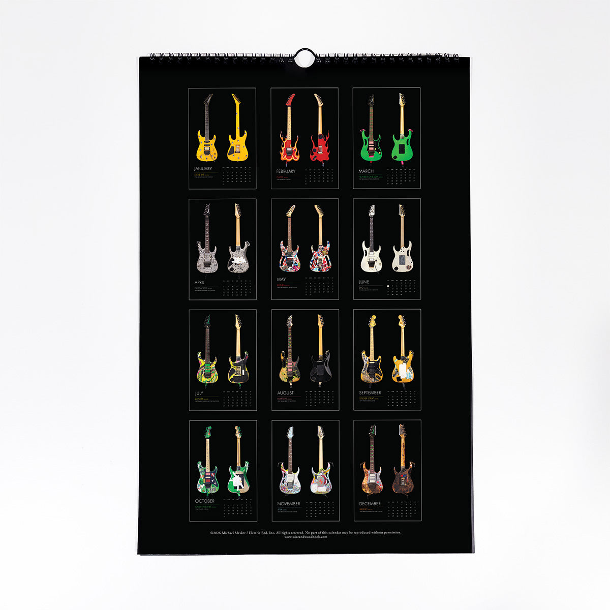 A spiral-bound wall calendar page featuring a grid of 12 electric guitars in various colors, displayed against a clean white background.